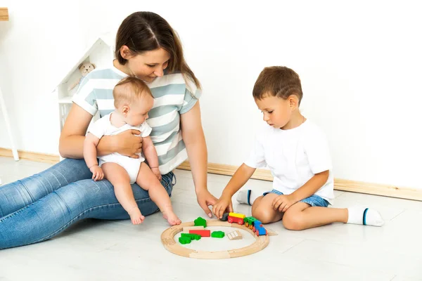 Mother Sitting With kids playing game Indoors — Stockfoto