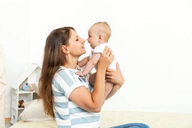 Young happy Mother playing with small baby