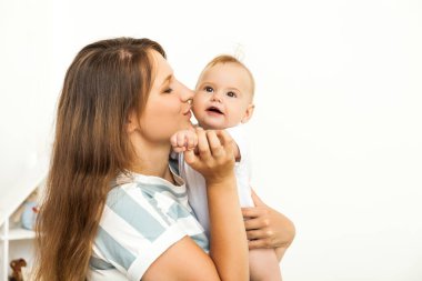 Young happy Mother playing with small baby