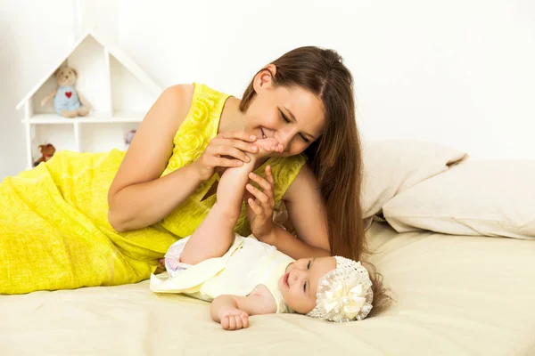 Jeune mère heureuse jouant avec un petit bébé — Photo