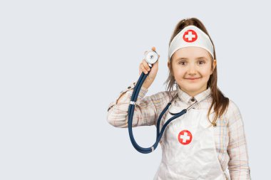 Beyaz arka planda steteskopla doktorculuk oynayan komik kız.