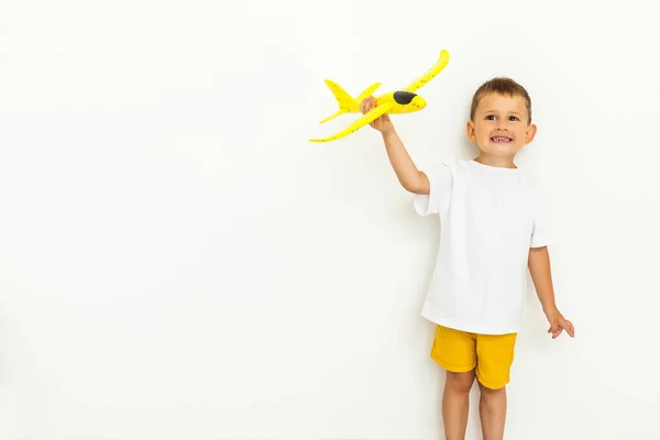 可愛いです男の子とともにおもちゃ飛行機上の白い背景 — ストック写真