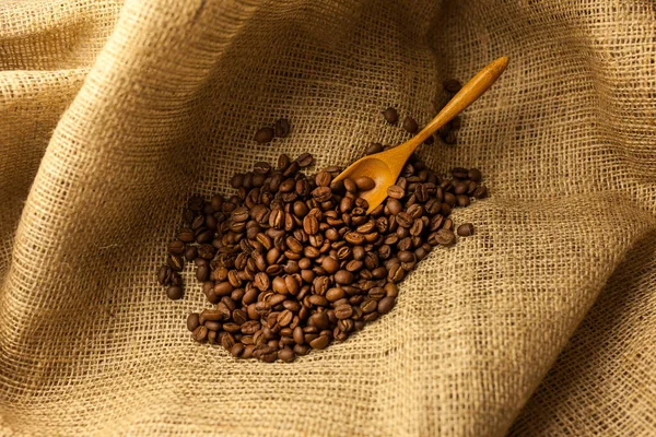 Coffee Beans Spilling Burlap Bag Scoop Textured Map Surface — Stock Photo, Image