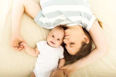 Mutlu bir anne bir yatakta yatarken bebek öpüşme Üstten Görünüm.