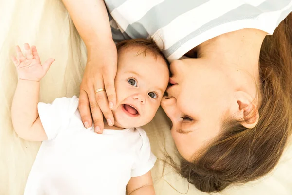 Vista Superior Una Madre Feliz Besando Bebé Acostado Una Cama —  Fotos de Stock