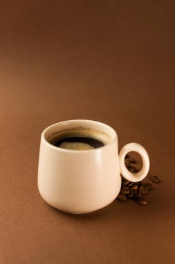 Arka planda kahve çekirdekleri olan bir fincan kahve. Metnin için boşluk kopyala