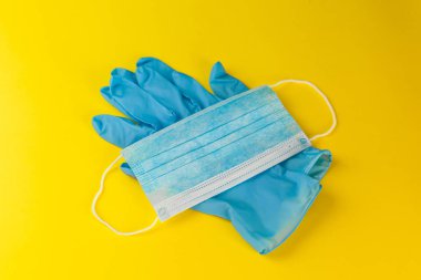 Sarı arka planda koruyucu maske ve eldivenler. Roman Coronavirus 2019-NCoV. Yazıt Coronavirüs 'ü durdurun..