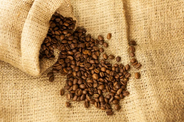 Granos Café Arabica Esparcidos Una Bolsa Sobre Fondo Textura Fábrica — Foto de Stock