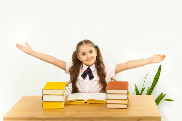 机の上に本がたくさんある側に手で幸せな女の子 ホームラーニングコンセプト — ストック写真