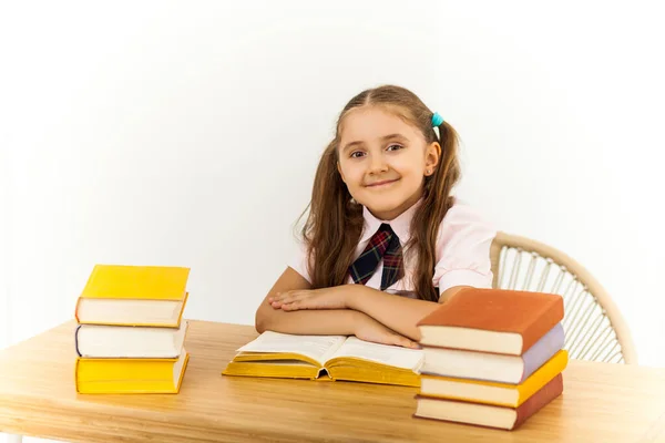 Masasında Bir Sürü Kitabı Olan Mutlu Küçük Bir Kız Beyaz — Stok fotoğraf