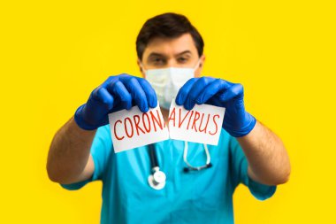Koronavirüs karantinası kavramı. Roman Coronavirus 2019 NCoV. Sarı zemin üzerinde steteskopu olan doktor beyaz kağıdı Coronavirus sözcüğüyle yırt.