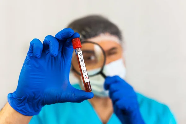 Técnico Laboratório Máscara Olhando Através Uma Lupa Tubo Amostra Sangue — Fotografia de Stock