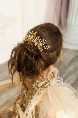 Boncuk süslemeli güzel mezuniyet saç stili. Moda elbisesi içinde güzel bir kız çocuğu.