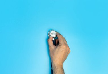 Doktorlar Bir steteskop tutuyor açık mavi arka plan yatay formatı kapalı