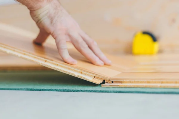 Usta döşeme tahtasını yerleştirir - teknoloji yüzen bir zemin inşa eder - bitirme işini tamir eder