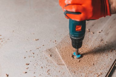 Usta, matkapla ısıtma borusuna yuvarlak bir delik açar. Telafi boşluğunu da hesaba katarak, işi bitirir.