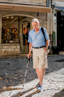 Saint-Paul-de-Vence, Provence / France - 28 Eylül 2018: Yaşlı gri saçlı adam sokakta yürüyor
