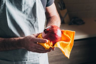 Şef olgun, sulu bir narı bir havluyla yıkadı ve sildi.