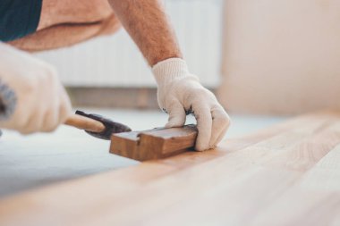 Usta çekiçle tahtayı yakınlaştırıyor - tamir ve bitirme işi