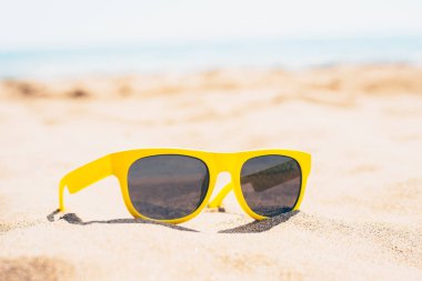 Plajda güzel, modaya uygun güneş gözlükleri. Gök mavisi suyun arkaplanına karşı. Yaz tatili.