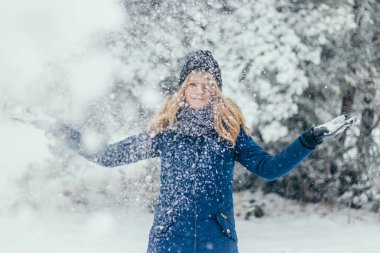 Ormanda karla oynayan çekici, güzel bir kış kadını. Matmazel eğlence için.