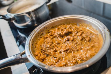 Tavuklu fileto, kızarmış soğan ve krema soslu havuç. Yakın plan ev yemeği.