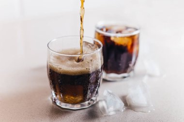 Buzlu, köpüklü, köpüklü bir bardakta bir kola fıskiyesi. Yakın plan ve uzayı kopyala.