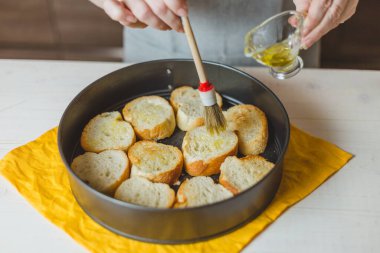Ev hanımı, kızarmış ekmeği tavada kızartıp kıtır kıtır sandviç yapıyor.