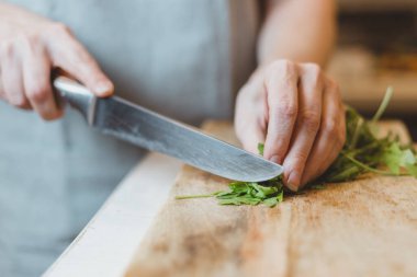 Mutfak masasında peynirli, domatesli, fındıklı ve roka soslu nefis geleneksel bruschetta yapan kadın.