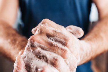 Kişisel hijyen - sabunla titiz bir el yıkama - sabunlu köpüklü erkek eli yakın çekim