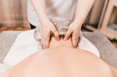 Kayropraktik uzmanı bir hastada servikal yaka bölgesi geliştirir. Osteokondroz tedavisi.