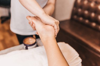 Ayak masajı kan basıncını normalleştirir. Bir kadın hastanın bacaklarına masaj yapar.