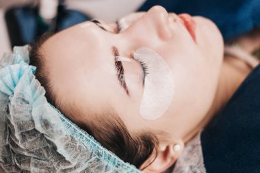 Kirpik uzatma işlemi - istemci sakin bir şekilde gözleri kapalı yatar