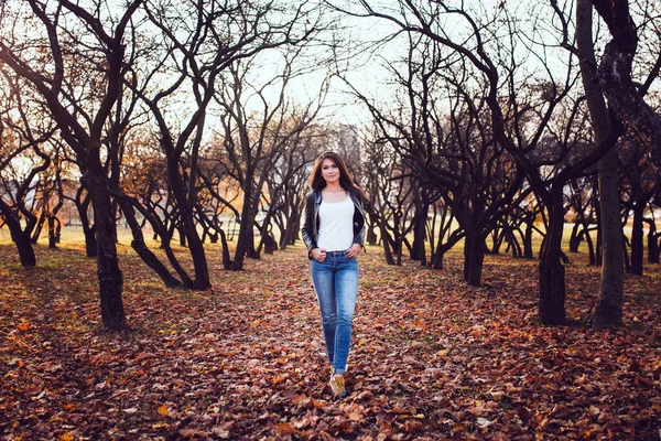 Eine Fröhliche Brünette Jeans Und Lederjacke Einem Apfelgarten Beim Spaziergang — Stockfoto