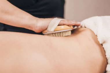 Masörün elindeki fırçayla sırt masajı - cildin üst tabakalarının uyarılması