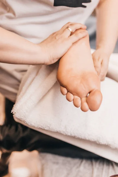 Masseur kneads and warms the feet before massage - Rub the whole foot with stroking movements