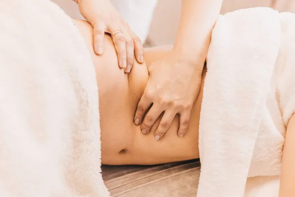 Masör yan yatarken hastaya masaj yapar.