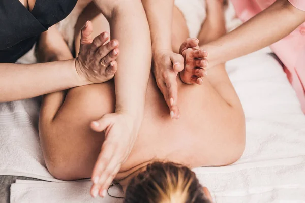 Aynı anda iki masaj terapistinin simetrik çalışması. Etkili Tayland masajı.