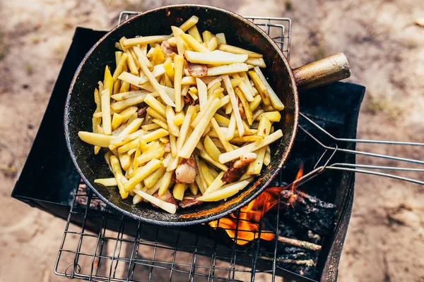 大铁锅 用细碎的土豆在森林里生火 用猪油煎土豆 — 图库照片