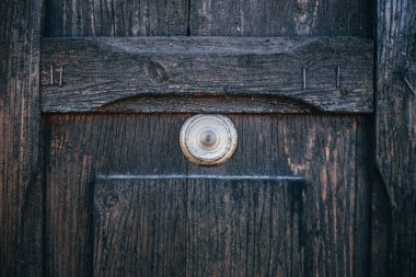 Gözetleme deliği olan eski ahşap kapı. Boya soyuluyor.