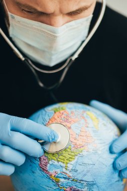 Steteskopu olan bir doktor, ABD 'de zatürree ve koronavirüs olan Dünya gezegeninin akciğerlerinin solunumunu kontrol eder.