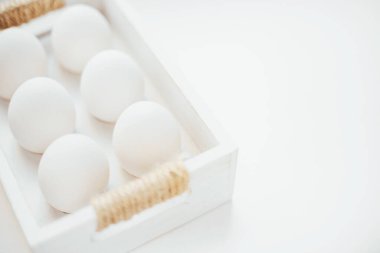 Beyaz arka planda ahşap bir kutuda tavuk beyazı çiftlik yumurtaları. Kopya alanı. Yazıtın.