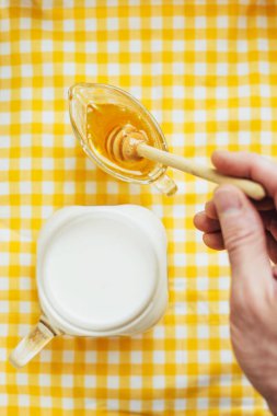 Bir adam kaşıkla bal toplar - ballı süt - bağışıklığı arttırır ve boğazı yumuşatır