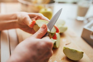Bıçaklı bir kadın eli, elmadan bir çekirdek kesmiş. Yakın plan pişirme.