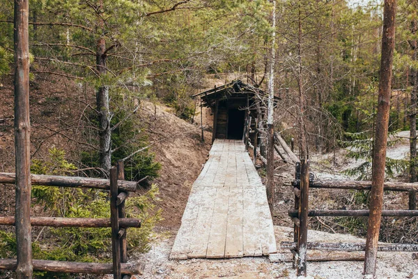 Entrance to a mountain mine in the forest - Klondike and gold rush - development of gold ore in the forest