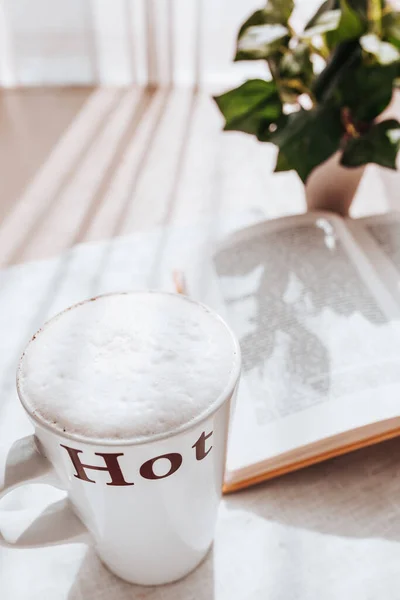 一杯自制卡布奇诺咖啡 桌上放着一本书 里面有厚厚的白色牛奶泡沫 — 图库照片