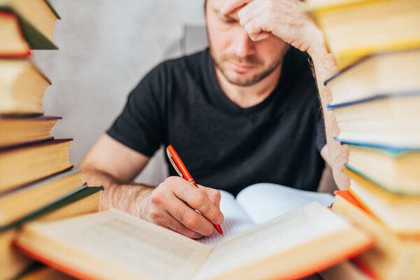 Кавказский человек устало излагает в библиотеке информацию из старой толстой пыльной книги - образование и наука
