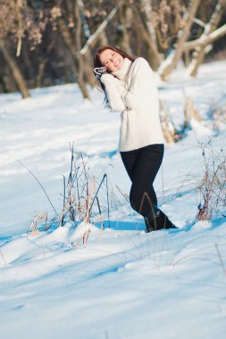 Minsk, Belarus - 30 Ocak 2012: Sıcak yün eldivenli ve kazaklı güzel bir kız karlı bir arazide yürüyor