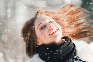 Minsk, Belarus - 30 Ocak 2012: Güneşli bir kış gününde genç ve çekici bir kız dışarıda gülüyor