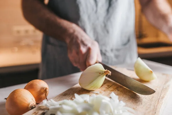 粗野的公手用一把大刀把一只白洋葱切成两半 一个合格的厨师 — 图库照片